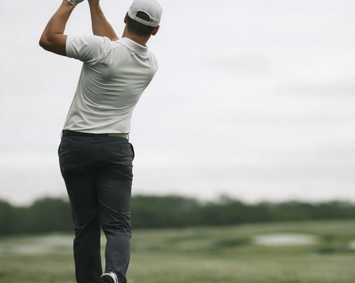 Man playing golf on a course with a cloudy sky