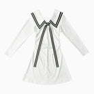White dress with black ribbon details on a white background