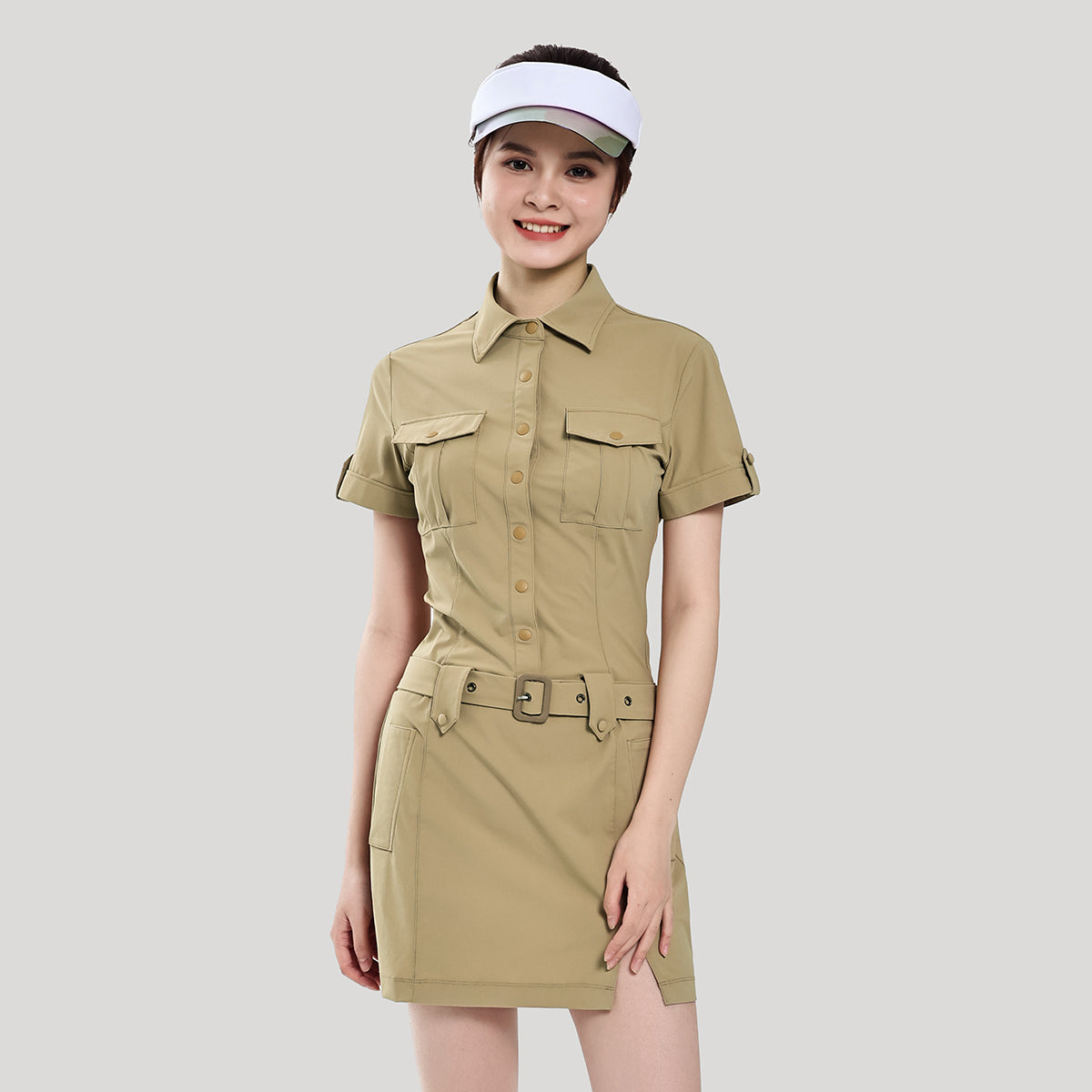 Woman wearing a beige safari-style dress with a belt on a light gray background